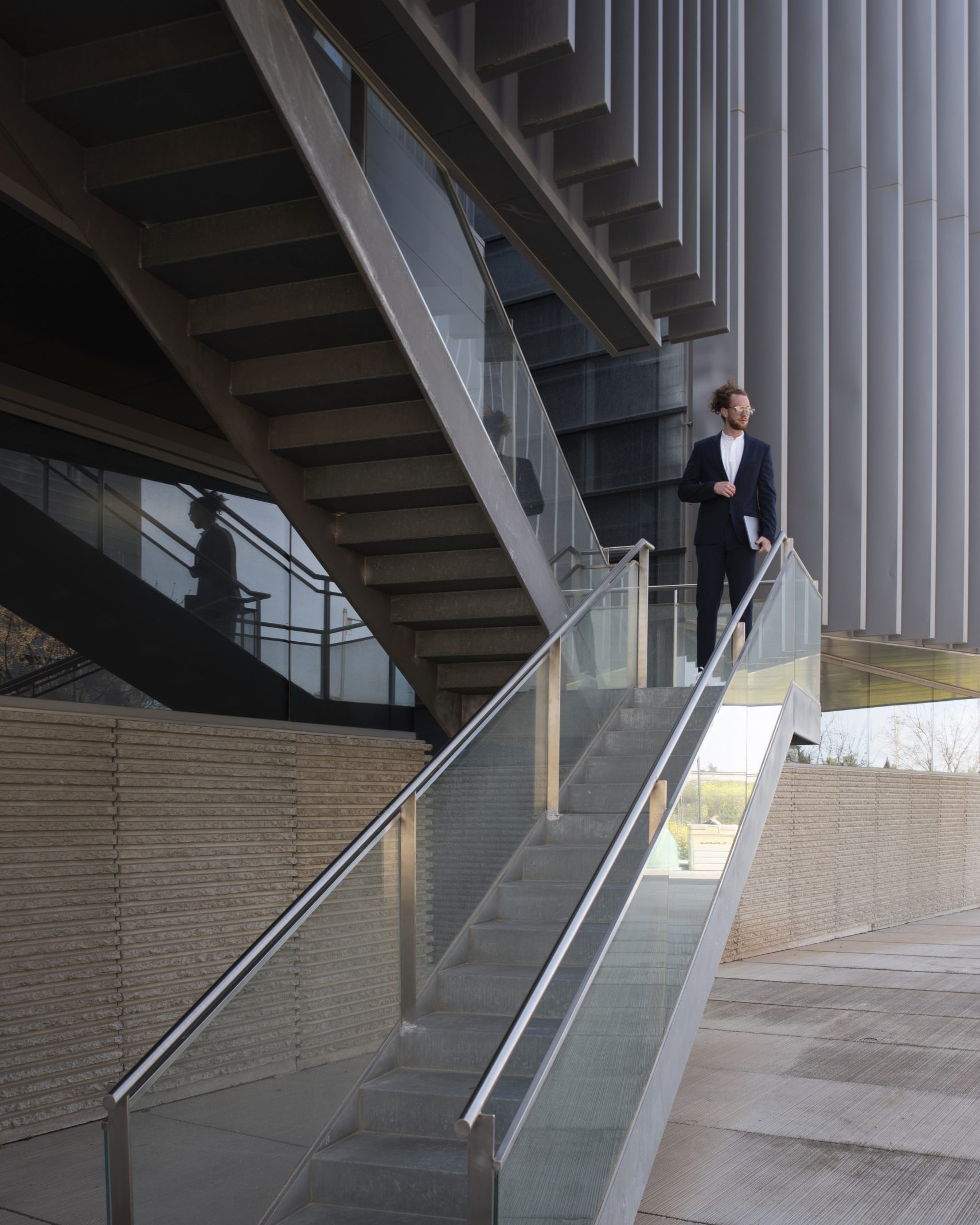 Scala architettonica in metallo e vetro con corrimano in acciaio realizzata da VS Line Lugano.